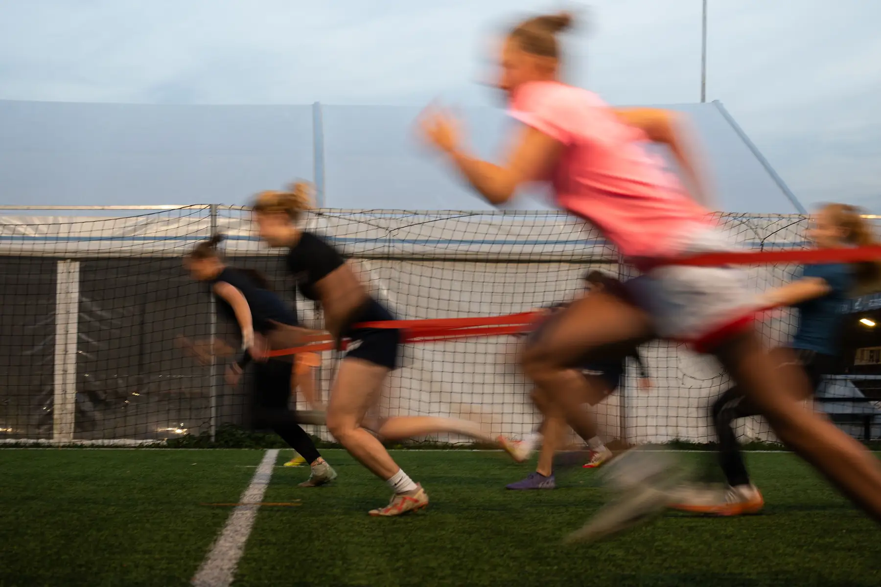 Sportovkyně při sprintu s odporovou gumou na tréninku Prague Speed Academy